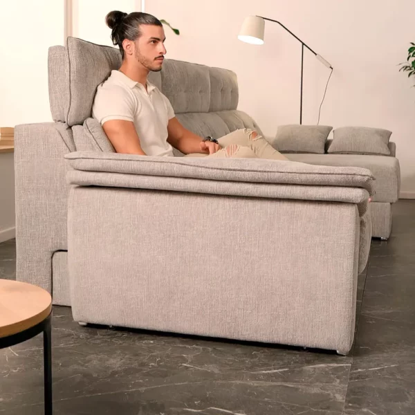 Lateral del sofá modelo KI en forma de L, con hombre sentado en el
